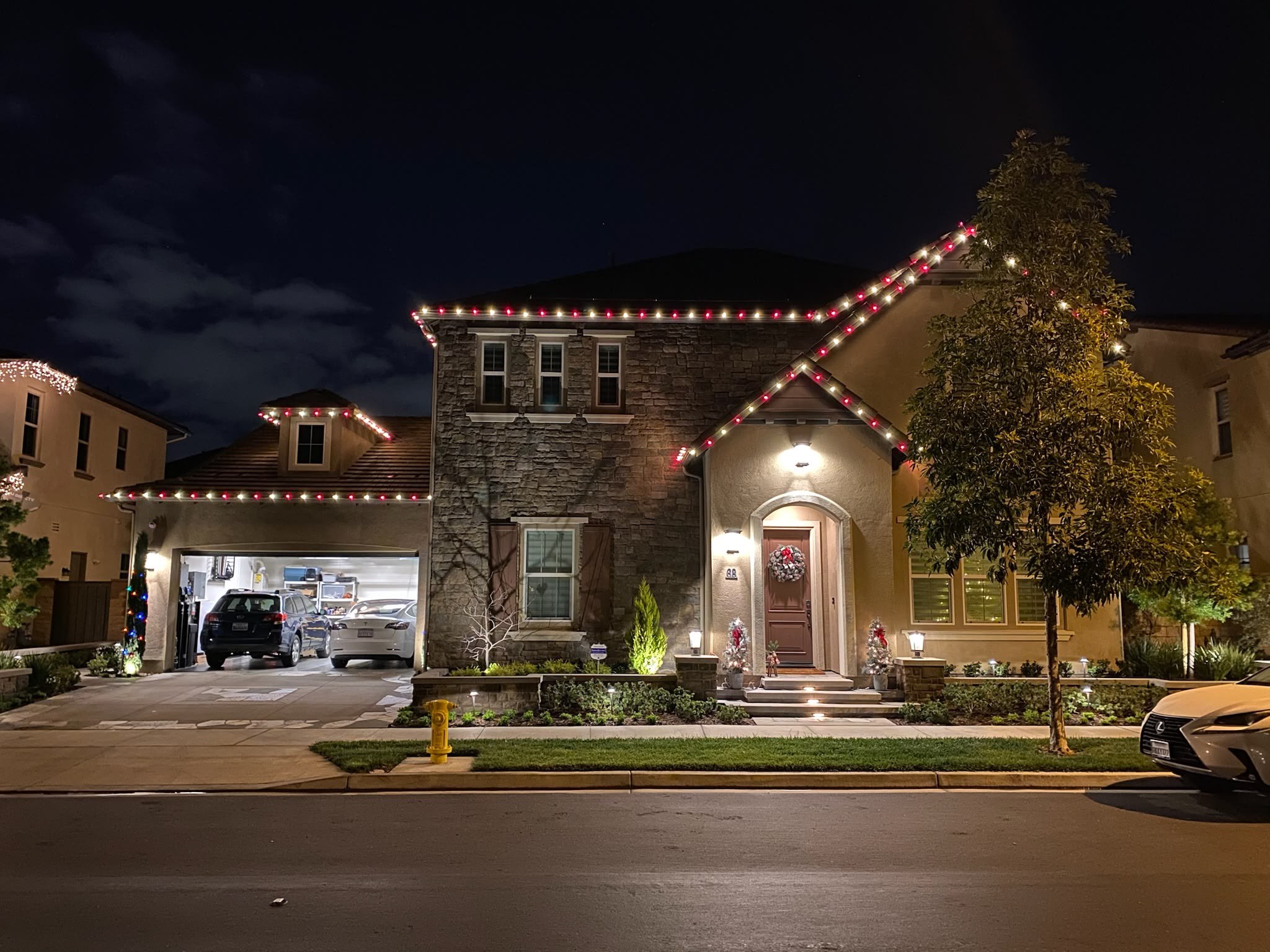 Real installation with alternating red and white bulbs outlining the gables of a two-story home.